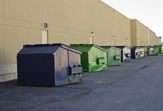 a row of yellow and blue dumpsters at a construction site in Hurdle Mills, NC